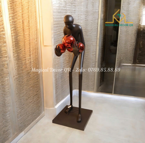 Black statue holding red ball